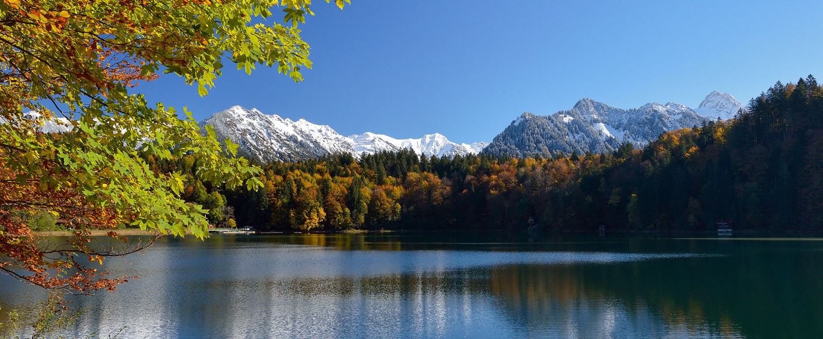 Freibergsee im Herbst mit verschneiten Bergen im Hintergrund